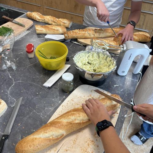 Schüler füllen Baguettes mit Knoblauchbutter