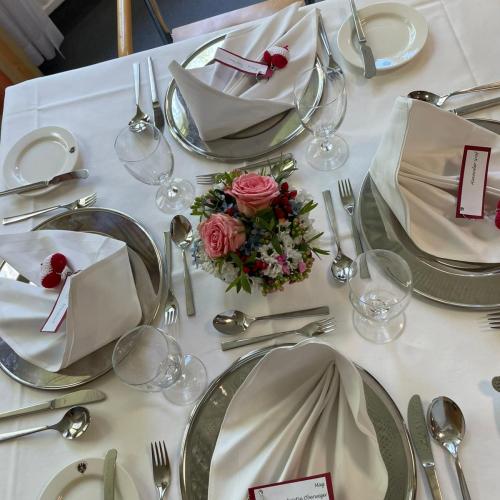 Gedeckter Tisch mit schön gesteckten Blumen in einer kleinen Schüssel