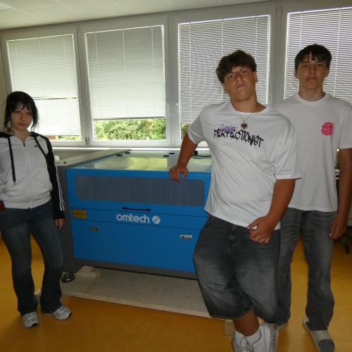 3 Schüler stehen vor einem Lasercutter