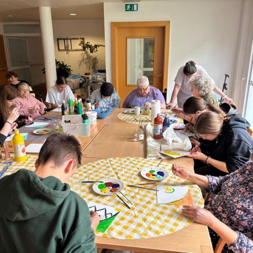 Schüler:innen und Bewohner des Pflegeheims malen gemeinsam.