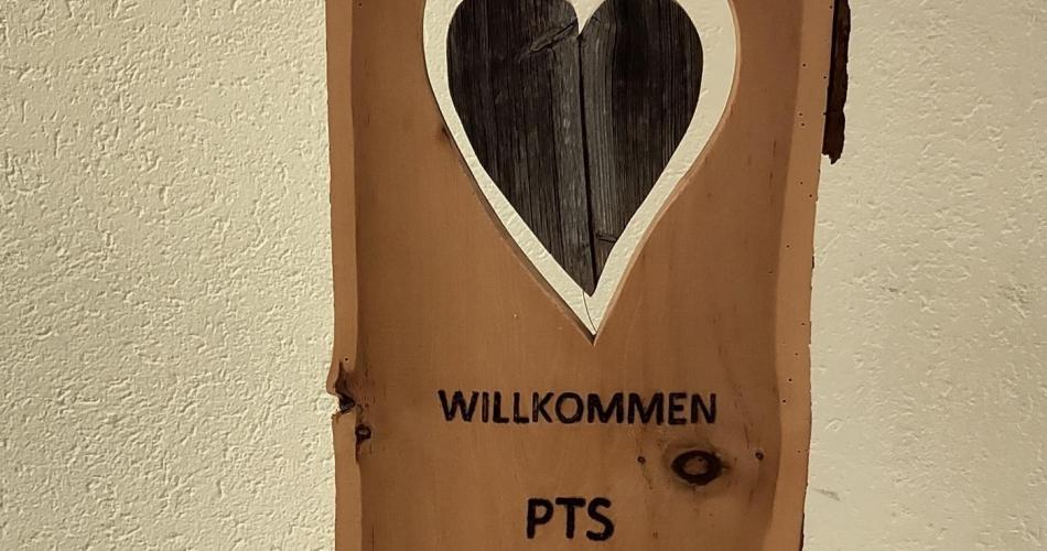 Holzbrett mit Herz und Aufschrift Willkommen Prutz