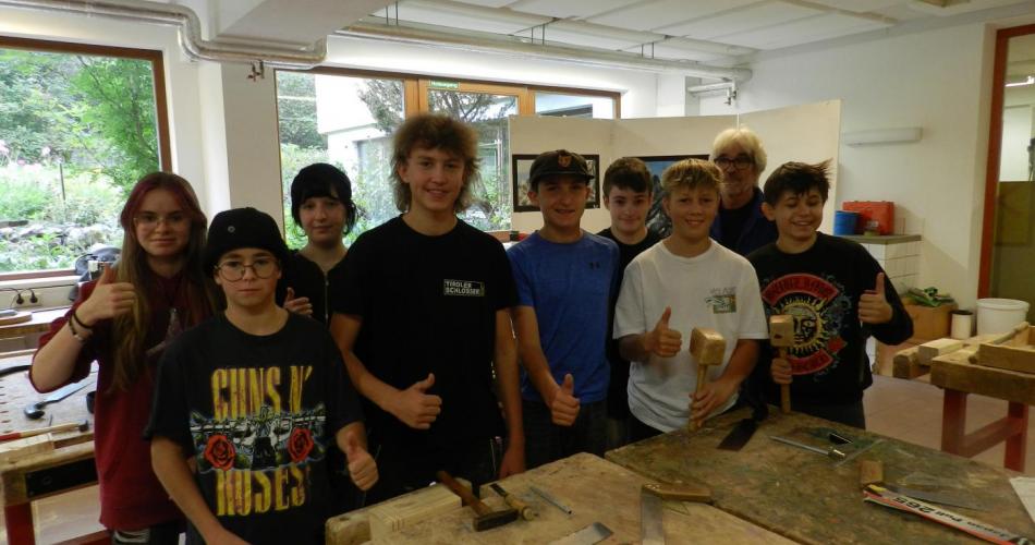 Schülergruppe in der Holzwerkstätte mit Daumen hoch