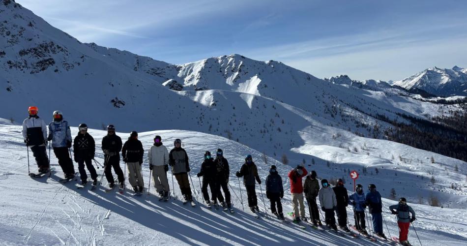 Gruppenfoto beim Schifahren - Schüler:innen stehen untereinander auf der Piste