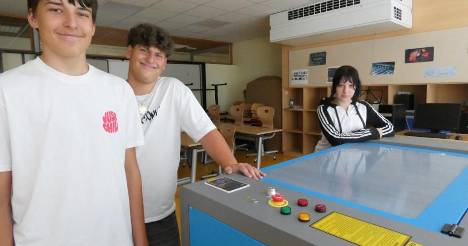 3 Schüler, die an einem großen Lasercutter stehen